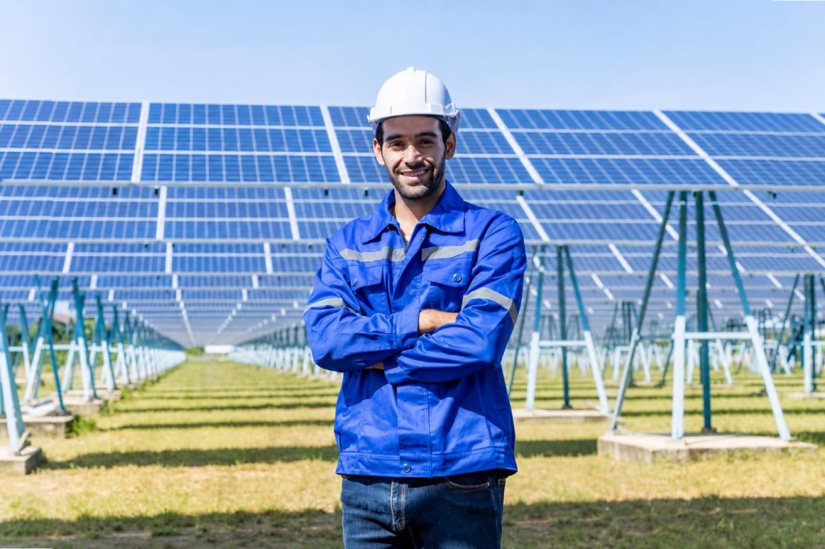 Solar professional standing in front of outdoor solar panels
