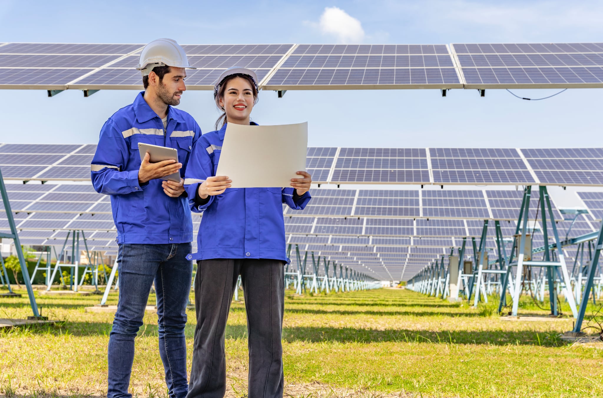 Two solar professionals reviewing a residential panel outdoors