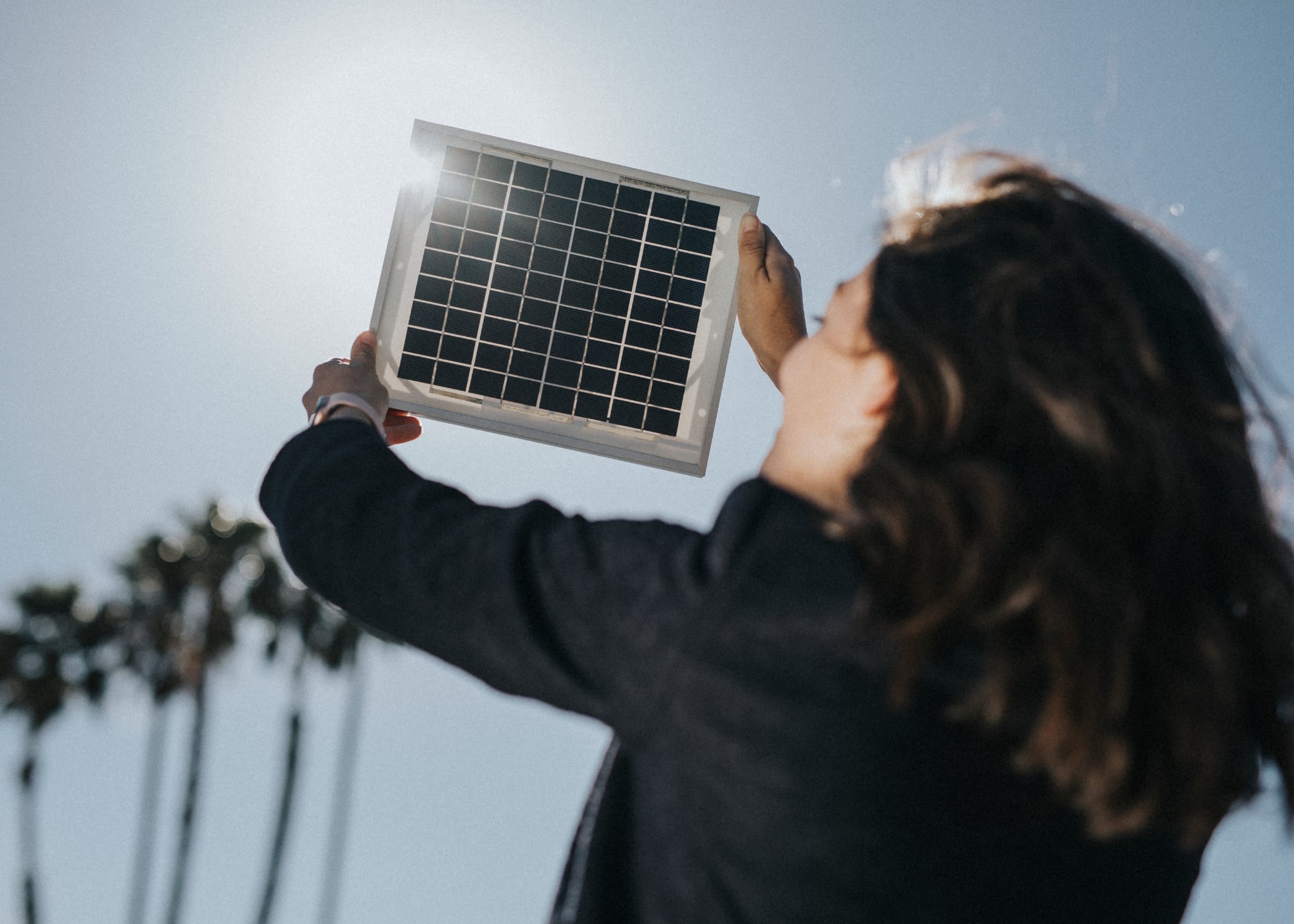Homeowner holding a small solar panel in daylight